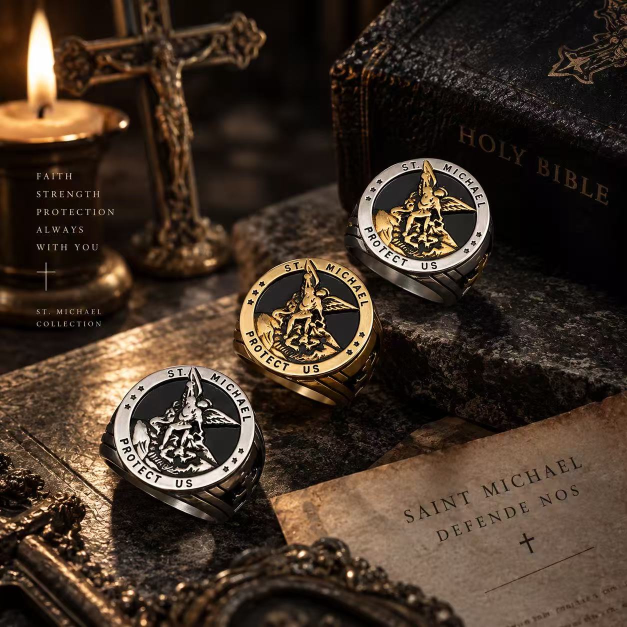 Three Saint Michael rings in silver-tone, gold-tone and two-tone finishes beside a Bible and cross.